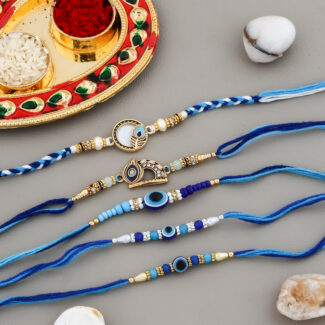 Top view of 5 designer blue-themed rakhis with Evil Eye beads, Kumkum-Chawal decorative Thali, and festive elements.
