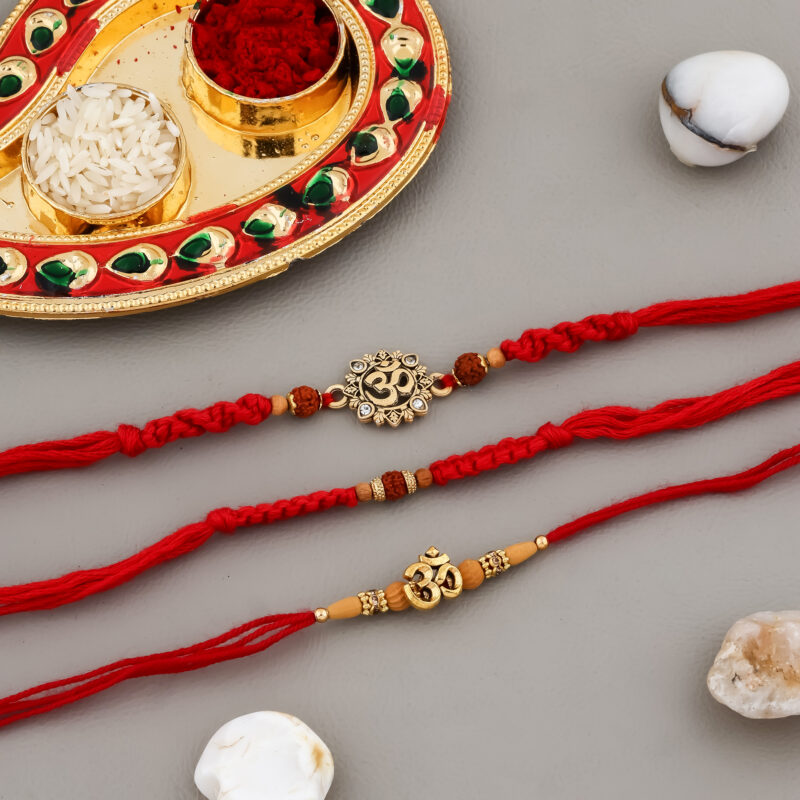 Traditional 3 Bhaiya Rakhi Set with Rudraksh beads, Om charms, red moli threads, decorative Kumkum-Chawal thali, greeting card, and chocolate.