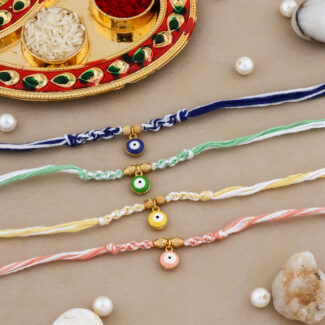 Colorful Evil Eye Bhaiya Rakhi Set with vibrant threads, protective evil eye beads, kumkum-chawal thali, greeting card, and chocolate.