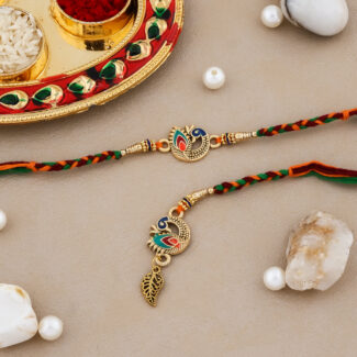 Multicolor Bhaiya-Bhabhi Rakhi set with peacock motifs, golden accents, and a decorative kumkum-chawal thali for Raksha Bandhan.