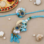 Elegant Bhaiya-Bhabhi Rakhi Combo with Blue Beads, Peacock Feather, Floral Accents, Tassels, Decorative Thali & Chocolate for Raksha Bandhan