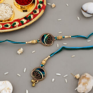 Ethnic-style Bhaiya-Bhabhi Rakhi set with blue-green thread, round golden centerpiece, traditional kumkum-chawal thali, and festive decorative background.