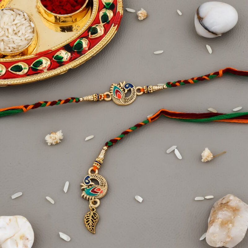 Multicolor Bhaiya-Bhabhi Rakhi set with peacock motifs, golden accents, and a decorative kumkum-chawal thali for Raksha Bandhan.